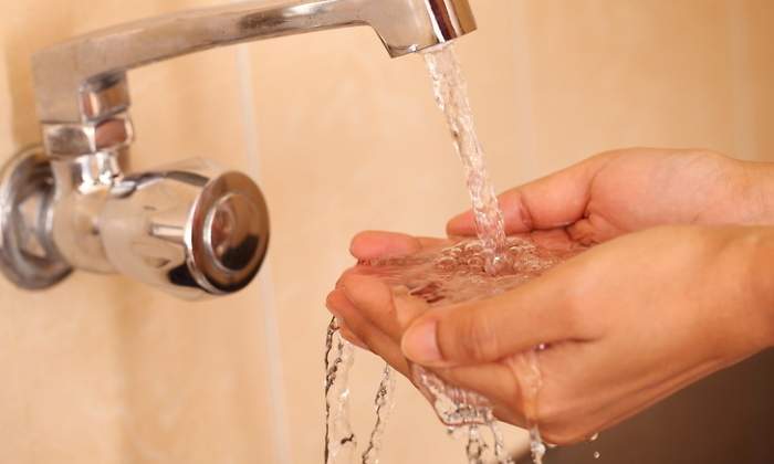 Unas manos reciben el agua de un grifo