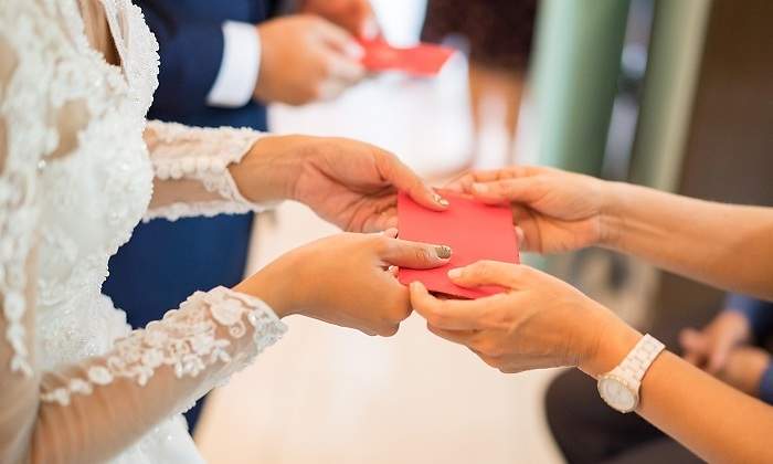 Una-persona-recibiendo-un--sobre-rojo-durante-su-boda-iStock.jpg