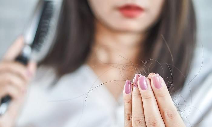Mujer-con-un-cepillo-en-la-mano-y-pelos-en-la-otra-iStock.jpg