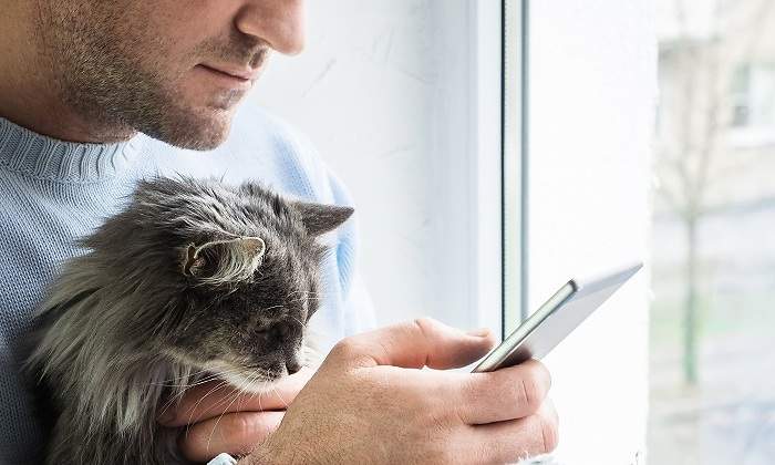 Hombre-mirando-el-movil-con-su-gato-iStock.jpg