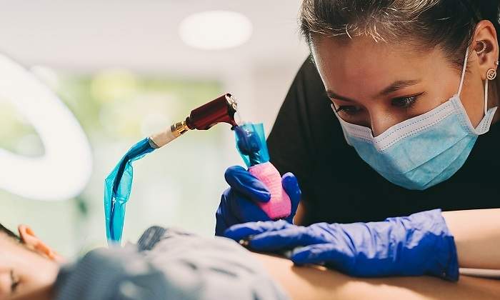 Mujer-con-mascarilla-tatuando-iStock.jpg