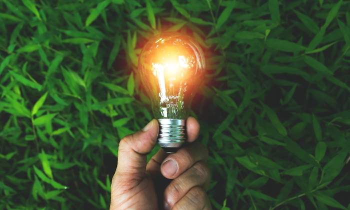 Una mano sostiene una bombilla que simboliza la energa solar renovable limpia