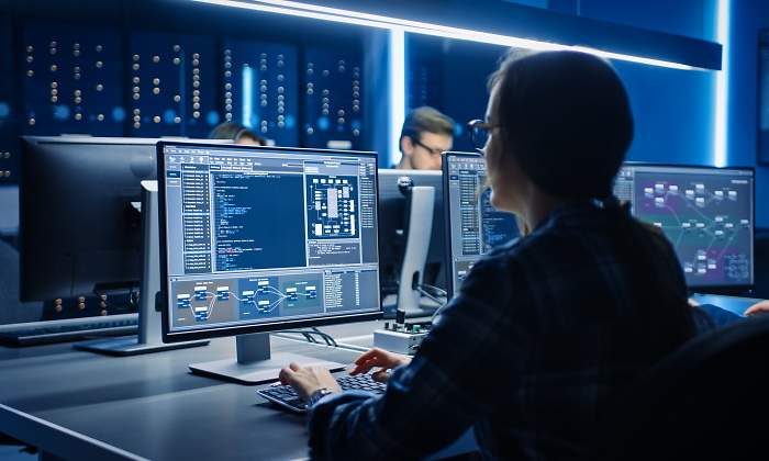 Una mujer programadora trabaja con su ordenador en un centro de datos