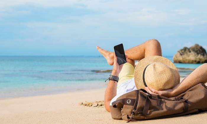 Chico-tumbado-en-la-arena-con-su-telefono-iStock.jpg