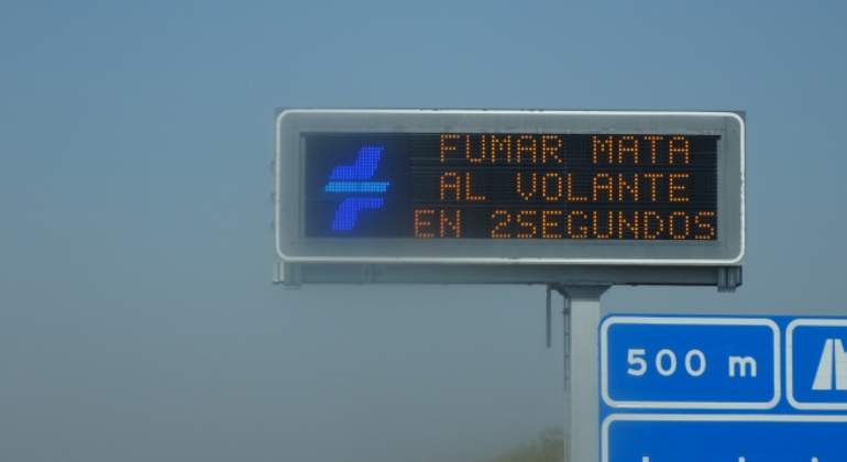 Cartel de la DGT advirtiendo de los riesgos de fumar en la conducción.