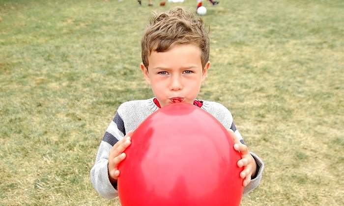 Un-nino-pequeno-hinchando-un-globo-rojo-iStock.jpg
