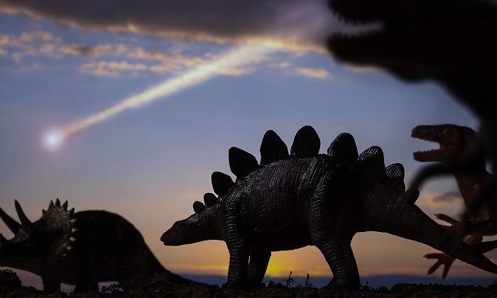 Diferentes-dinosaurios-caminando-mientras-cae-un-meteorito-iStock.jpg