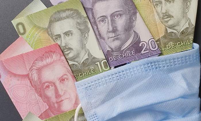Billetes de peso chileno con una mascarilla