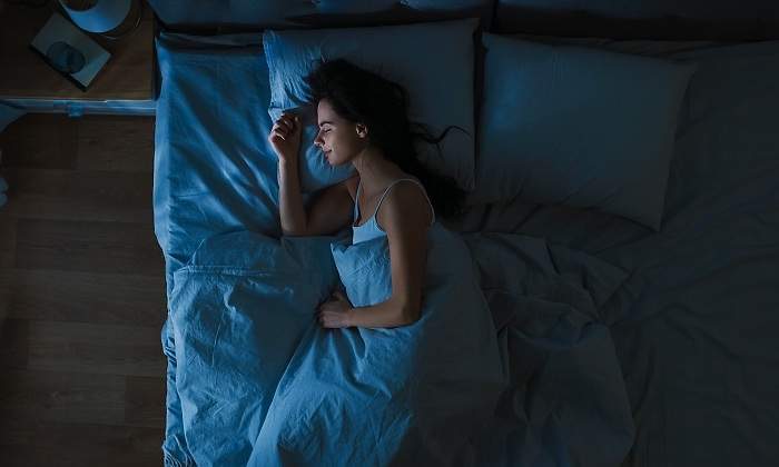 Una-mujer-durmiendo-por-la-noche-en-su-cama-iStock.jpg