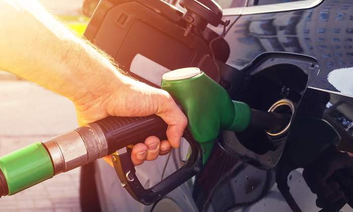Una persona reposta lo que parece un combustible verde o ecocombustible en su vehculo