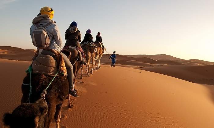Un-grupo-de-personas-en-camello-paseando-por-el-Sahara-iStock.jpg