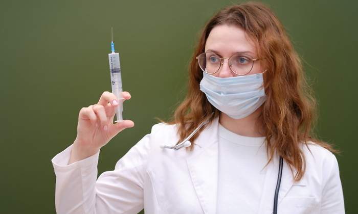 Una doctora con una jeringuilla en una clase