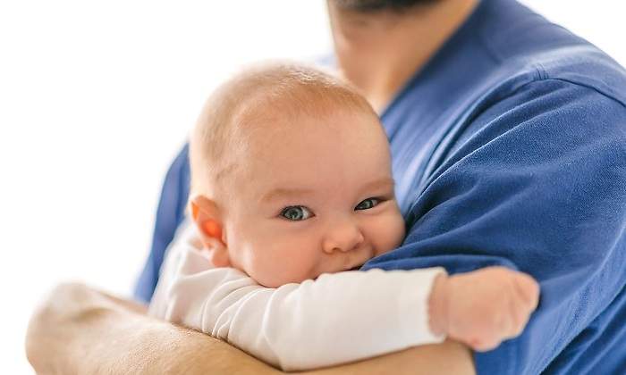 Un-bebe-en-brazos-de-un-hombre-con-camiseta-azul-iStock.jpg