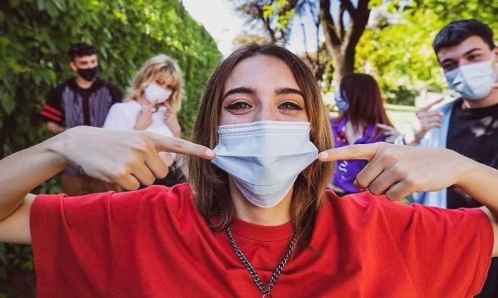 Mujer-y-amigos-senalando-a-sus-mascarillas-iStock.jpg