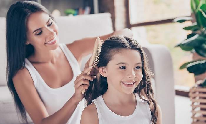 Una-mujer-cepillandole-en-cabello-a-una-nina-iStock.jpg