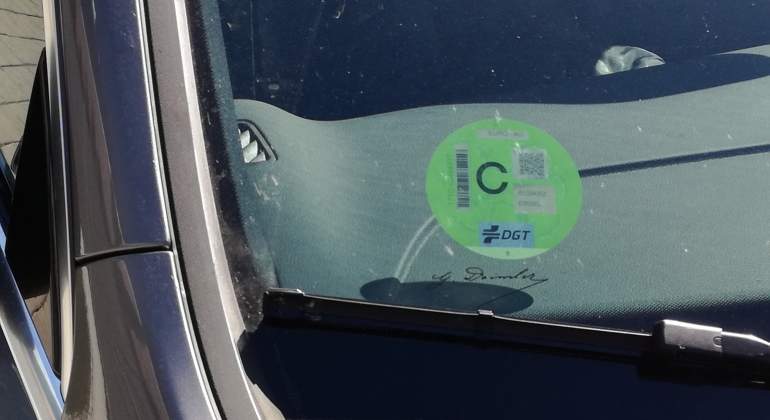 Coche con una pegatina de la DGT aparcado en una calle de Madrid.