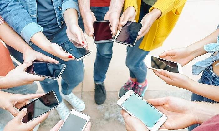 Grupo-de-amigos-a-traves-de-sus-telefonos-moviles-inteligentes-iStock.jpg