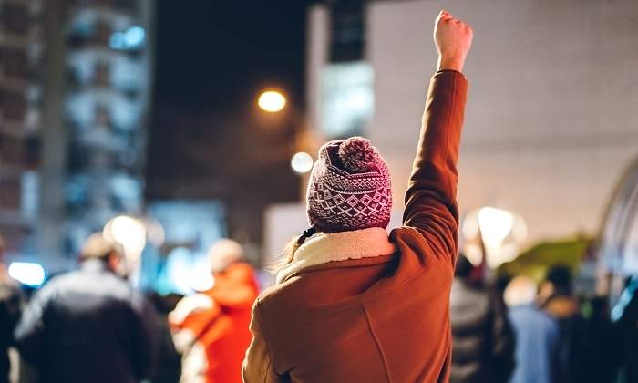 Una manifestante alza el brazo en la calle