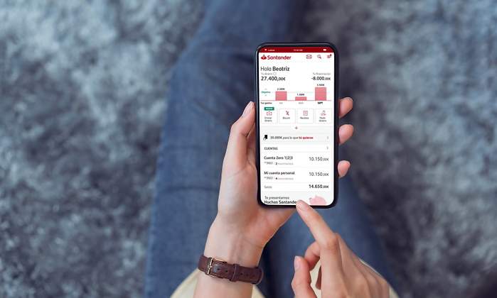 Una persona sostiene un mvil donde se ejecuta la app de Banco Santander