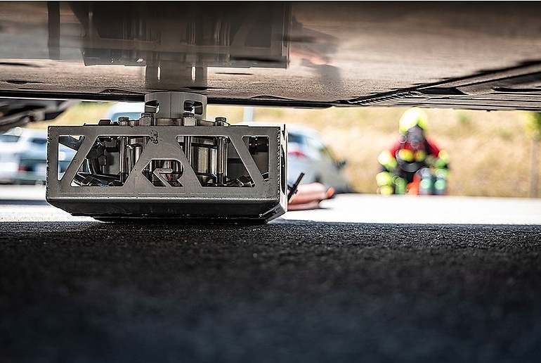 El equipo situado debajo del coche, tras perforar la batería
