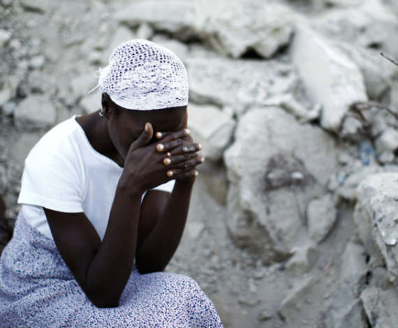 Haitiana llora junto a los escombros